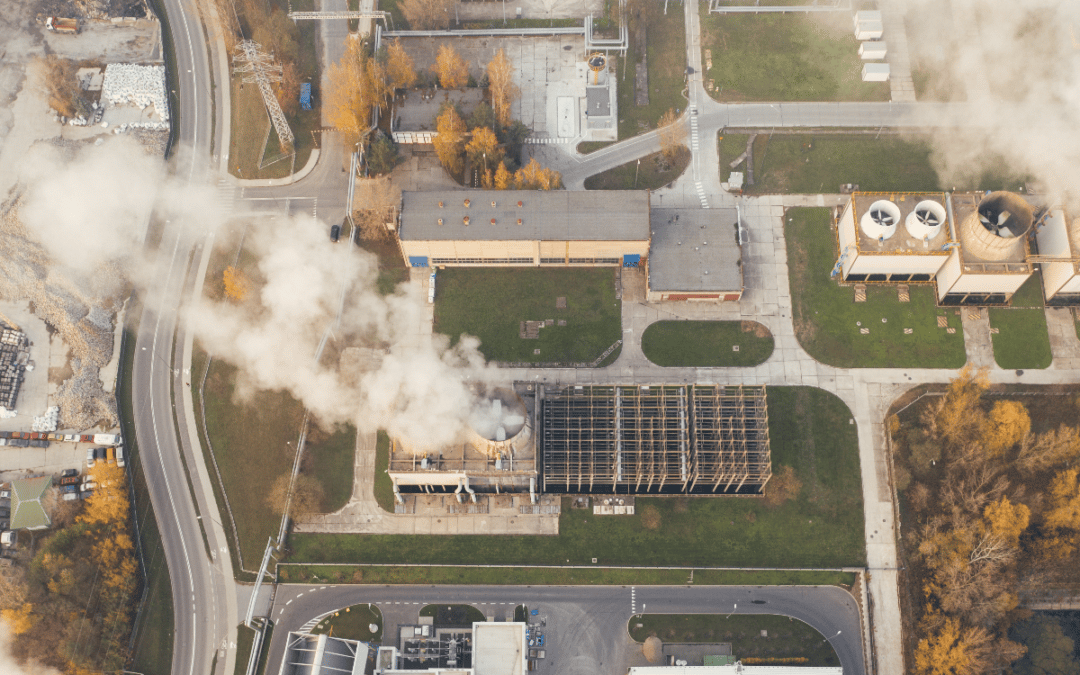 A bird's eye-view shot of several factories pumping out emissions.